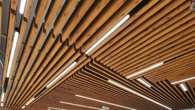 Office lobby with a timber baffle ceiling and linear lights